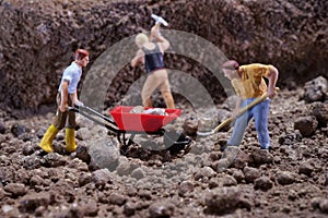 MiniatureÃÂ Contruction workers working lifting stone using shovel